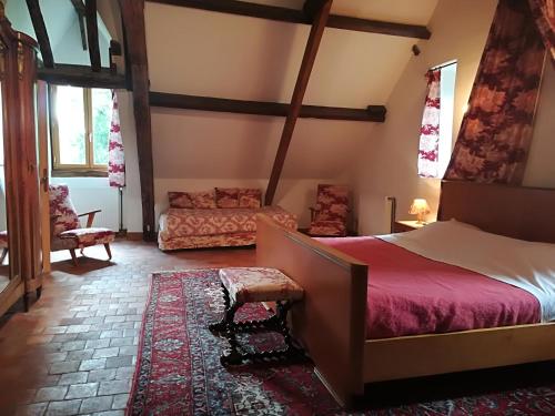 a bedroom with a bed and a couch at Chambres d'hôtes de Champendu in Azy-le-Vif