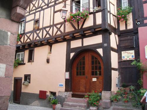 an old building with a wooden door and stairs at A studio apartment on the first floor of a wine grower s house in Riquewihr