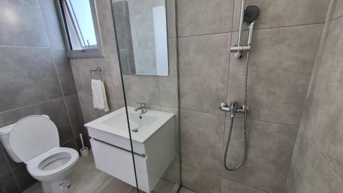 a bathroom with a shower and a toilet and a sink at Protaras Heights- Hana in Paralimni