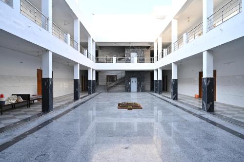 an empty room with a large hall with white columns at Sarvjanik Hindu Dharamshala in Nīmri