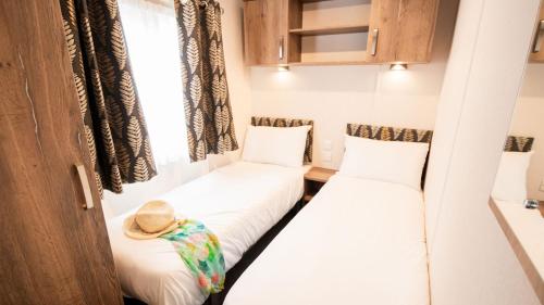 two beds in a small room with a hat at 3. Supreme OD 3 Caravan with Decking in Ringwood