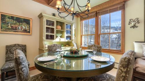 a dining room with a glass table and chairs at Palmyra 3D by AvantStay Gorgeous Condo in Great Location in Telluride