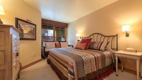 a bedroom with a bed and a couch and a window at Palmyra 3D by AvantStay Gorgeous Condo in Great Location in Telluride