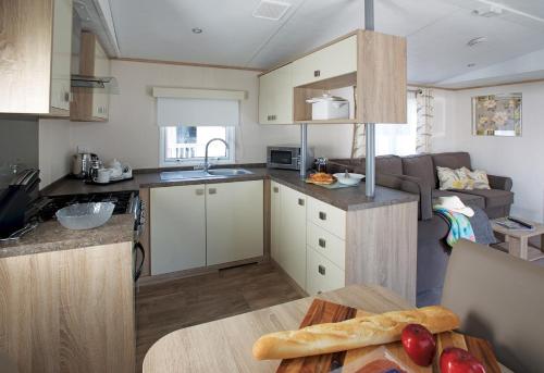 a small kitchen with a table and a couch at 7. Supreme OD 3 Caravan with Decking in Ringwood