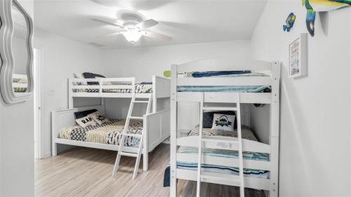 a room with white bunk beds and a ceiling fan at 209 E Andrews Ave, Unit A in Wildwood