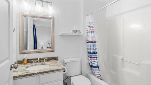 a bathroom with a toilet and a sink and a mirror at 209 E Andrews Ave, Unit A in Wildwood