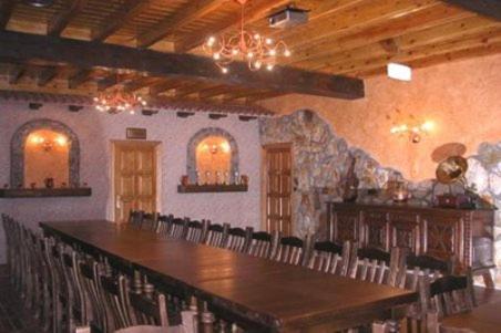 Habitación grande con mesa grande y sillas. en Hostal la Cepa, en Aldeanueva de Ebro