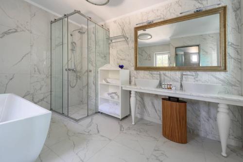 a bathroom with two sinks and a shower at Santorini Gem in Órmos Athiniós