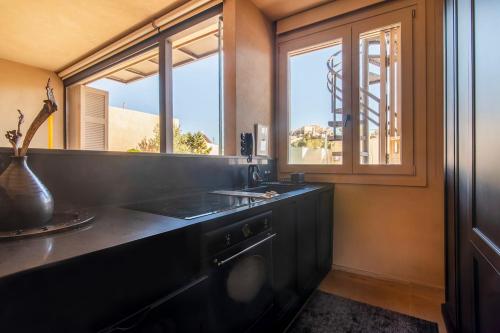 a black kitchen with a sink and a window at Architects Masterpiece Villa with Private Rooftop in Athens