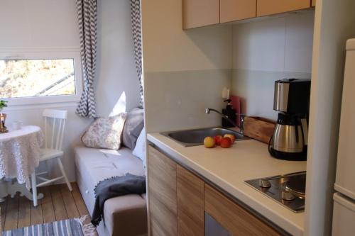 a kitchen with a sink and a couch in a room at Lillstugorna in Ljungskile