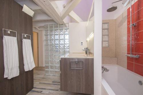 a bathroom with a sink and a bath tub at AppartCosy 04 in Vitré