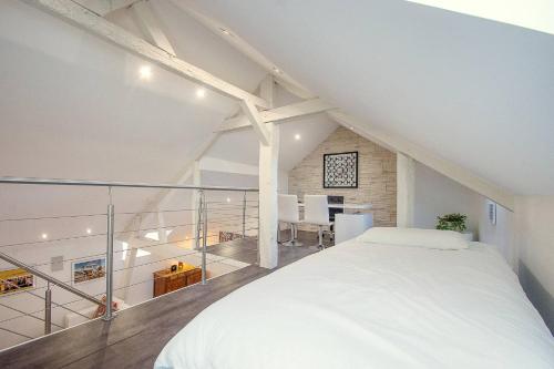 a bedroom with a large white bed in a attic at AppartCosy 04 in Vitré