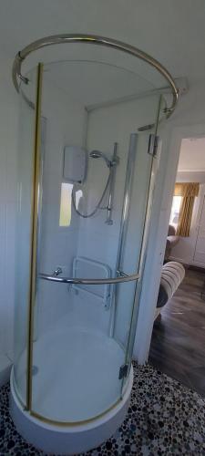 a glass shower stall in a room with a floor at Rosehill Beach in Hemsby