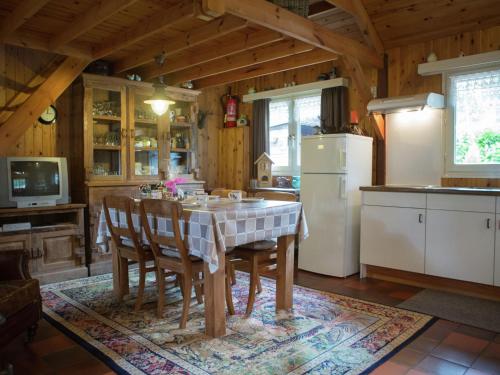 a kitchen with a table and chairs and a refrigerator at Luxurious Chalet in Oud Turnhout with Large Garden in Oud-Turnhout