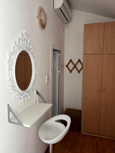 a bathroom with a white toilet and a mirror at Apartments Teodora Obala in Petrovac na Moru
