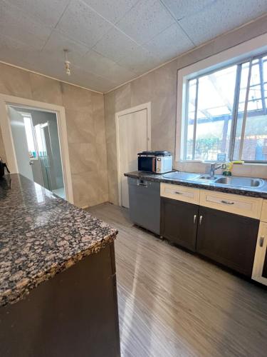 an empty kitchen with a sink and a counter top at Seaside Sanctuary in Aspendale