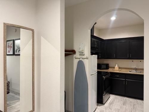 a kitchen with black cabinets and a white refrigerator at Crystal Inn - Garth Rd in Baytown
