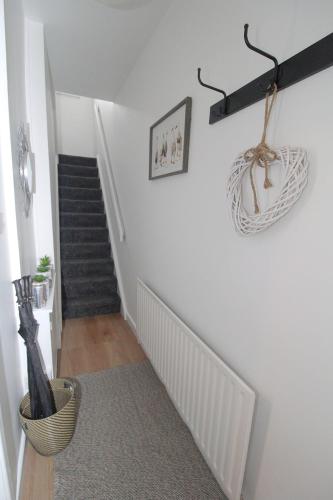 a hallway with a staircase with white walls and a stair case at Big Fish - Charles St South in Belfast
