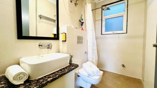 a bathroom with a sink and a toilet and a mirror at ZEN Medicity - Boutique Hotel Gurgaon in Gurgaon