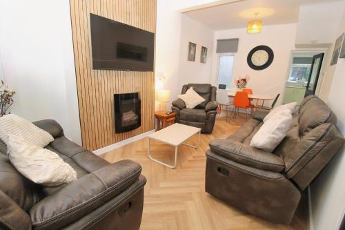 a living room with two leather couches and a fireplace at Big Fish - Charles St South in Belfast