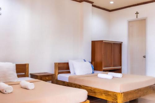 a room with two beds and a cross on the wall at Anda De Boracay White Sand Resort in Anda
