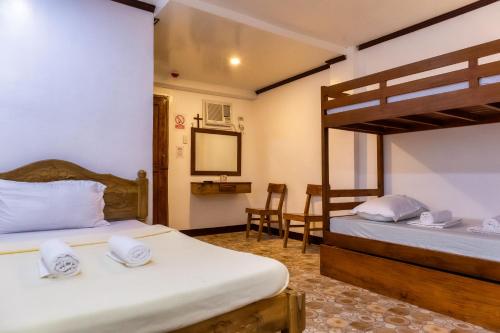 a bedroom with two beds and a bunk bed at Anda De Boracay White Sand Resort in Anda