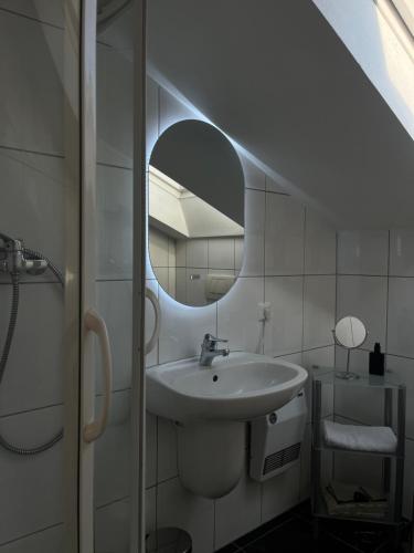 a white bathroom with a sink and a mirror at Weingut Sauer-Kettermann in Enkirch