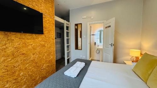 a bedroom with a bed with a flat screen tv on the wall at Town Lodge in Newquay