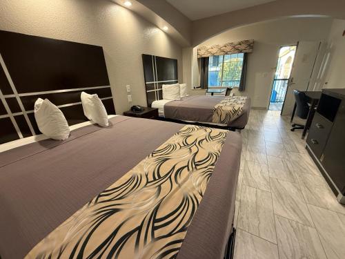 a hotel room with two beds and a television at Crystal Inn - Garth Rd in Baytown