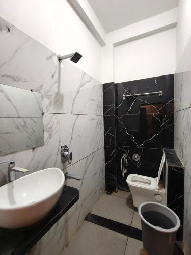 a bathroom with a sink and a toilet at Hotel Vriksh Stay in Godarpura