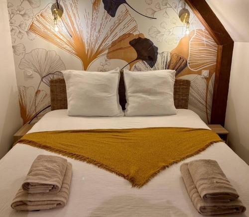 a bedroom with a bed with two towels on it at AppartCosy 15 in Vitré