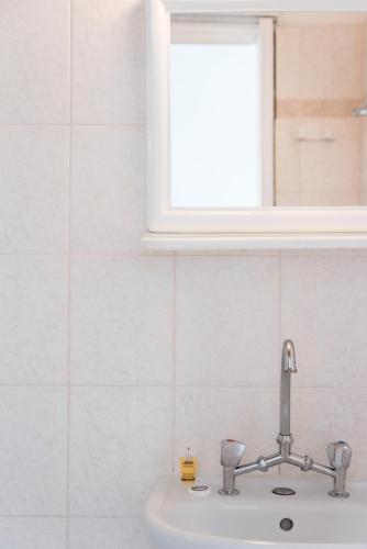 a sink in a bathroom with a window above it at Fardini Seaside Hotel in Kavos