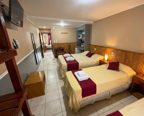 a hotel room with two beds and a kitchen at Apart Hotel Belgrano in Perico