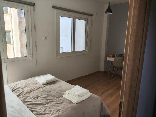 a bedroom with a bed with two towels on it at Ulysses Apartments Ermou in Athens