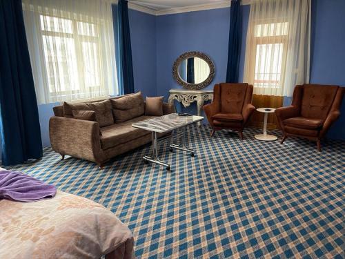 a living room with a couch and two chairs and a mirror at Kutlu suit otel in Eskiömerler