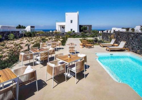 a villa with a swimming pool and a resort at La Ponta Villas & Suites in Akrotiri