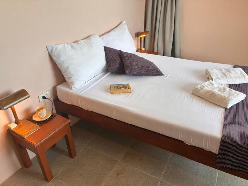 a bedroom with a bed with a table and a book at The Lazy Tiki in Buenavista