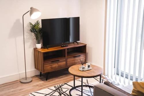 a living room with a flat screen tv on a entertainment center at Staycay - Modern 1-Bed Apartment in Manchester City Centre in Manchester