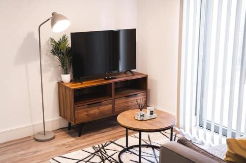 a living room with a flat screen tv on a entertainment center at Staycay - Modern 1-Bed Apartment in Manchester City Centre in Manchester