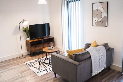 a living room with a couch and a television at Staycay - Modern 1-Bed Apartment in Manchester City Centre in Manchester