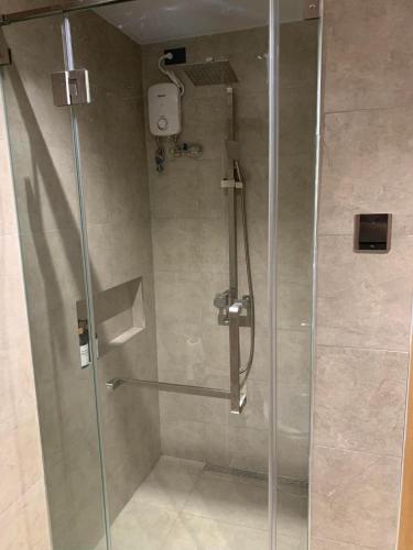 a shower with a glass door in a bathroom at Cozy 1BR with Balcony, Sea View and Pool - Fast WiFi - Snug Sanctuary in Talisay