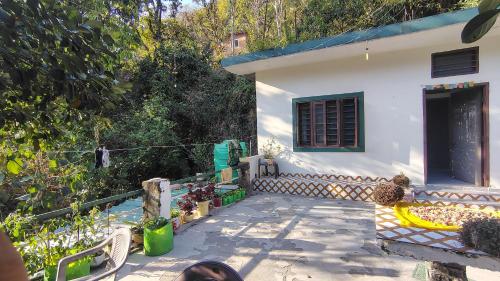 a small white house with a fence and a patio at vishranti homestayy in Rishīkesh