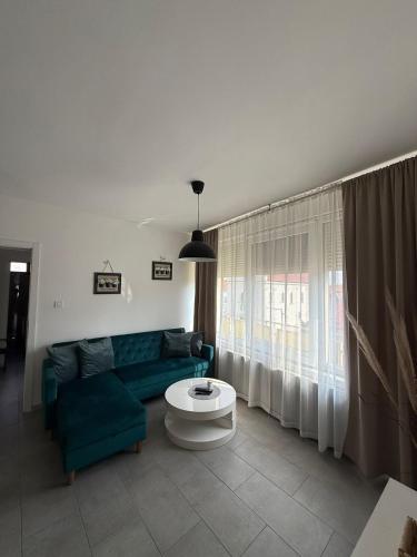a living room with a green couch and a table at Apartman "WALKOW", SELF CHECK IN, FREE PARKING in Vukovar