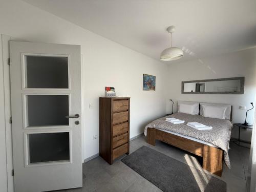 a small bedroom with a bed and a door at Apartman "WALKOW", SELF CHECK IN, FREE PARKING in Vukovar