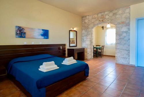 a bedroom with a blue bed with towels on it at Mandilada Family Village - Seaview Villas in Marathokampos
