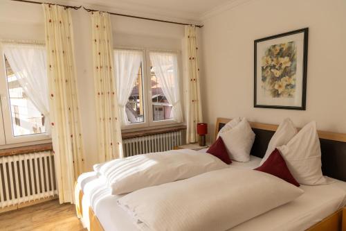 a bedroom with two beds and two windows at Ferienwohnungen Ruasers Ruah in Mittenwald