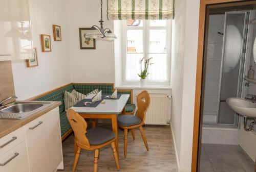a kitchen with a table and chairs and a sink at Ferienwohnungen Ruasers Ruah in Mittenwald