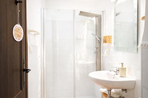 ein weißes Badezimmer mit Waschbecken und Dusche in der Unterkunft Habitaciones con encanto - Cal Alejandro in Montsonis