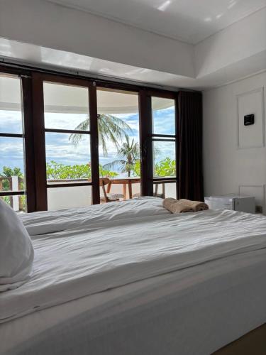 a bedroom with a bed with a view of the ocean at Lombok Coconut Hotel in Mangsit