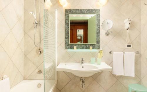 a bathroom with a sink and a shower and a mirror at Hotel Sierra Silvana in Selva di Fasano
